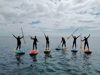 Gruppe af gæster på stand up paddleboards på havet ud for Hjarnø Camping