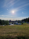 Aussicht über den Campingplatz Faaborg mit Wohnwagen und grüner Landschaft im Sonnenschein.