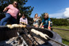 Familie bager snobrød over bål ved Nymindegab Camping.