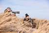 Two people birdwatching by the coast near Vedersø Strand Camping with telescopes.