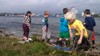 Children play and explore nature by the water’s edge at Svendborg Sund Camping.