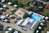 Aerial photo of Øster Hurup Camping with pool, buildings, and caravans.
