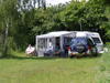 Campingvogn og bil parkeret på græsplads ved Feriebyens Camping, Rødvig.