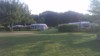 Green camping pitches with caravans and awnings.