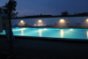 Heated swimming pool at Øster Hurup Camping illuminated in the evening.