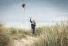 Woman flying a kite on the beach near Vedersø Strand Camping.